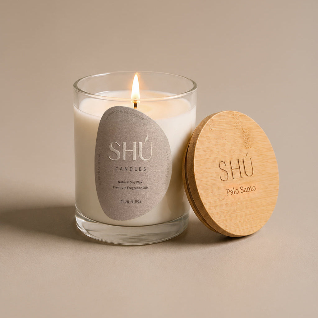 Palo Santo soy candle in clear glass with dark brown label, SHU Candles